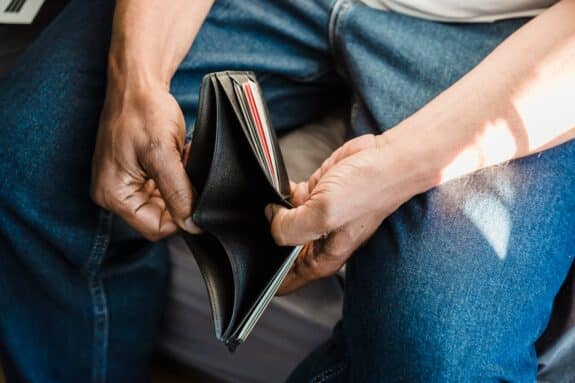 Man looking into an empty wallet